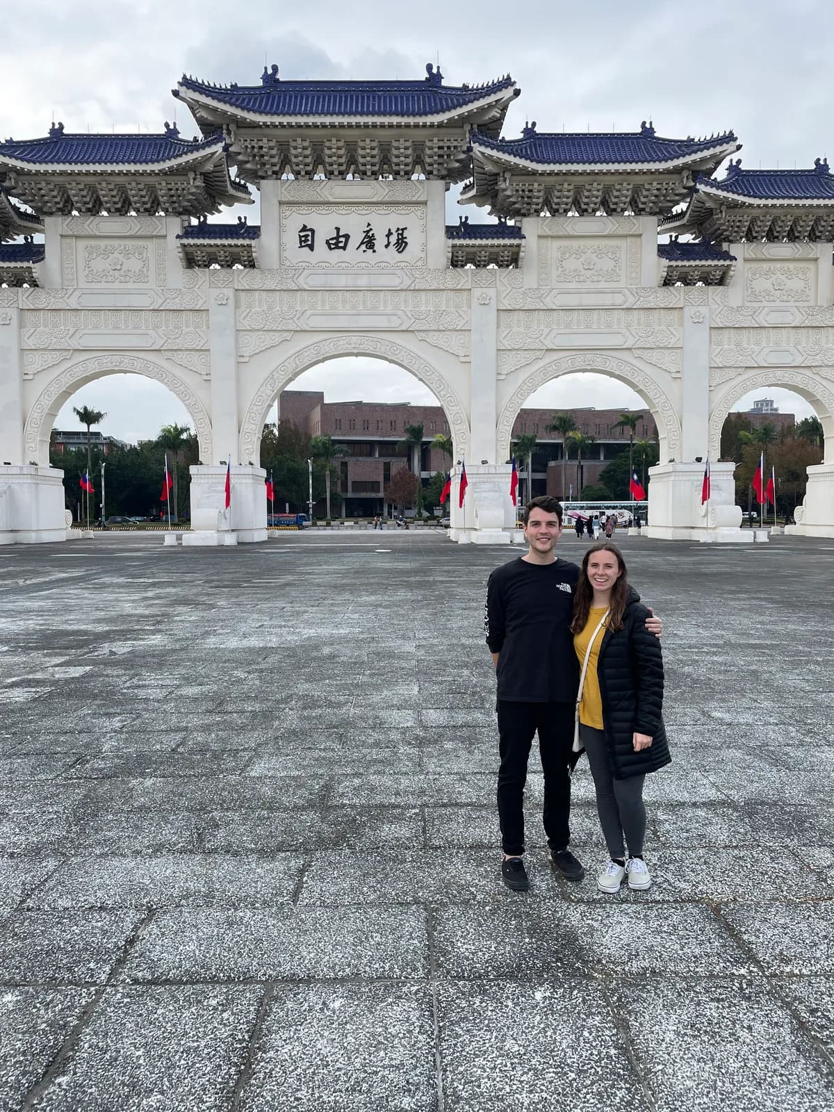 Nick and a companion in front of the white gate at Liberty Square