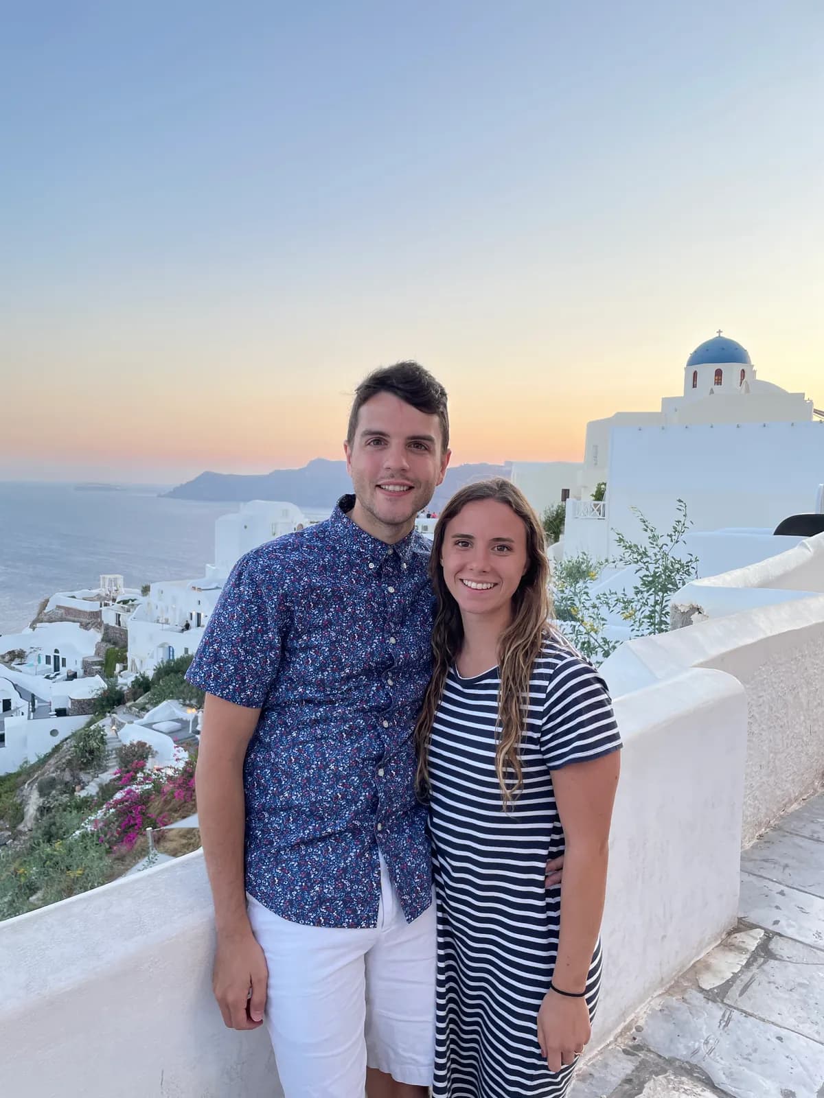 Nick and a companion at sunset above white buildings and a blue dome