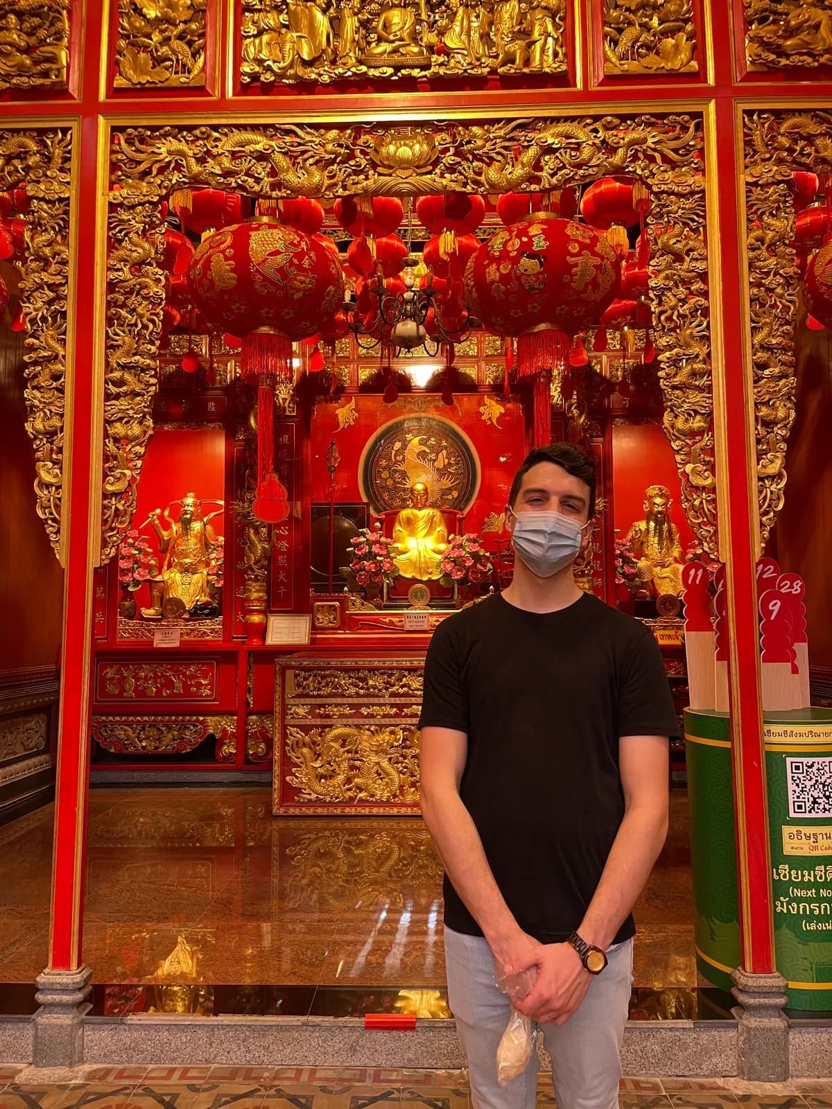 Nick in front of a red and gold shrine